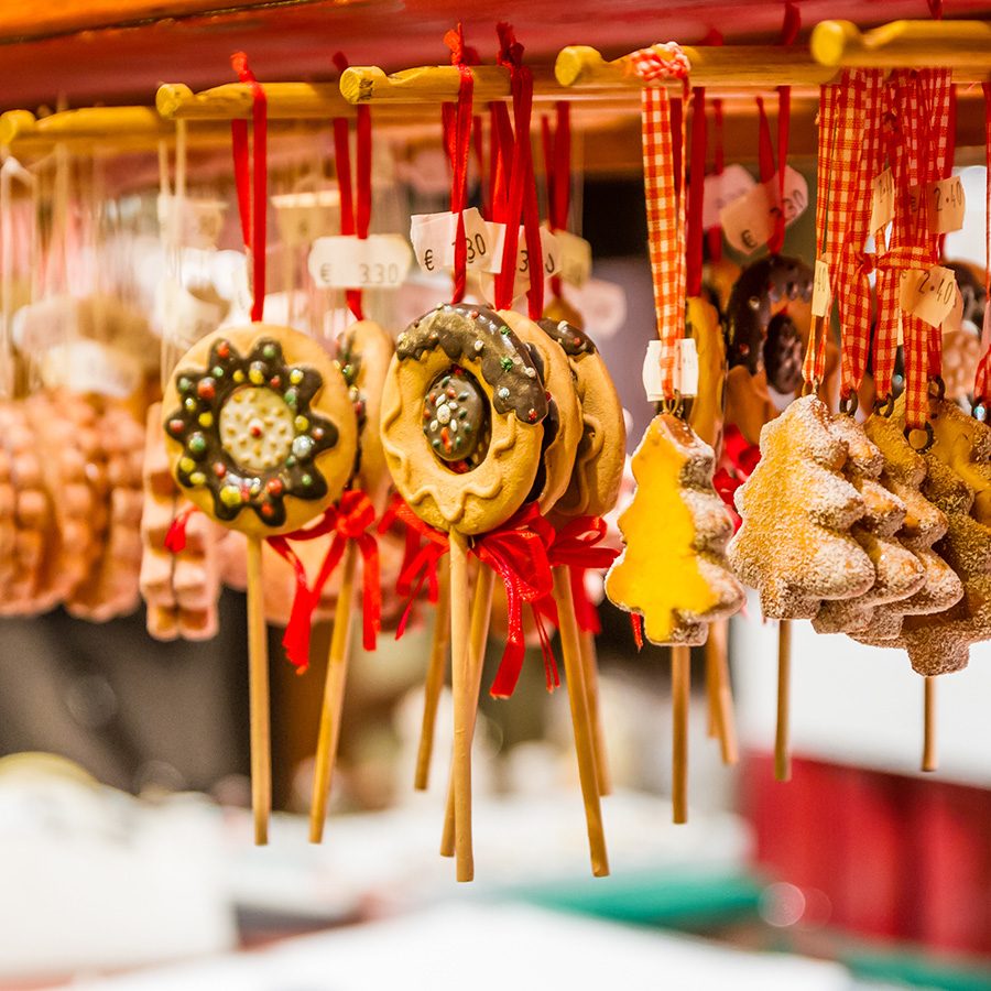 A close-up of hanging Christmas ornaments shaped to look like confectionary, at a market stall. 