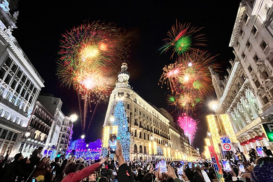 Crowds look on as fireworks light up the night sky on New Year’s Eve in the centre of Madrid
