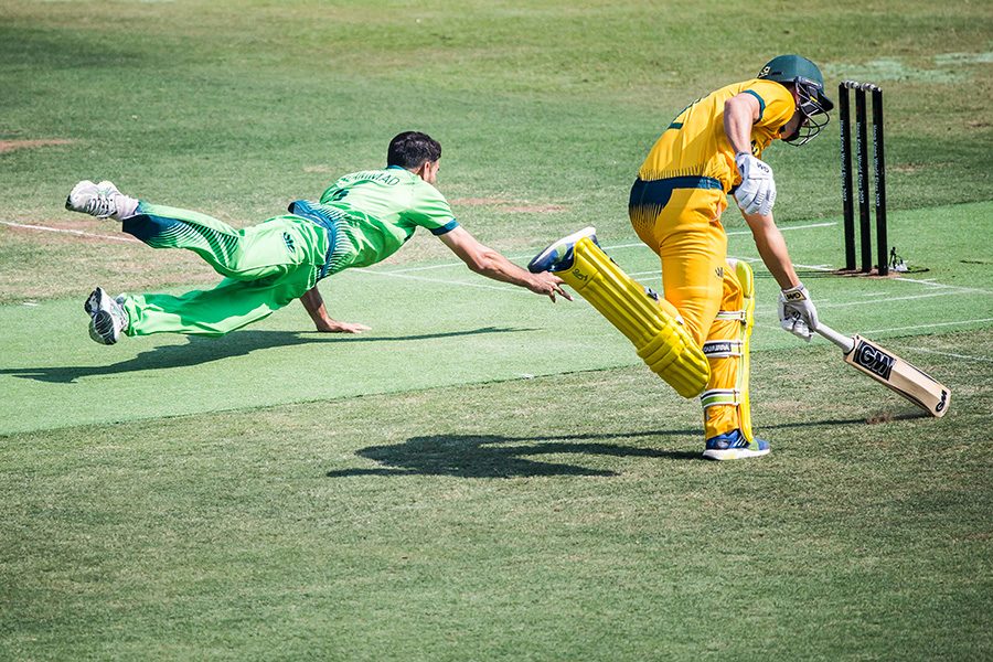 Cricket player dives as they defend a wicket