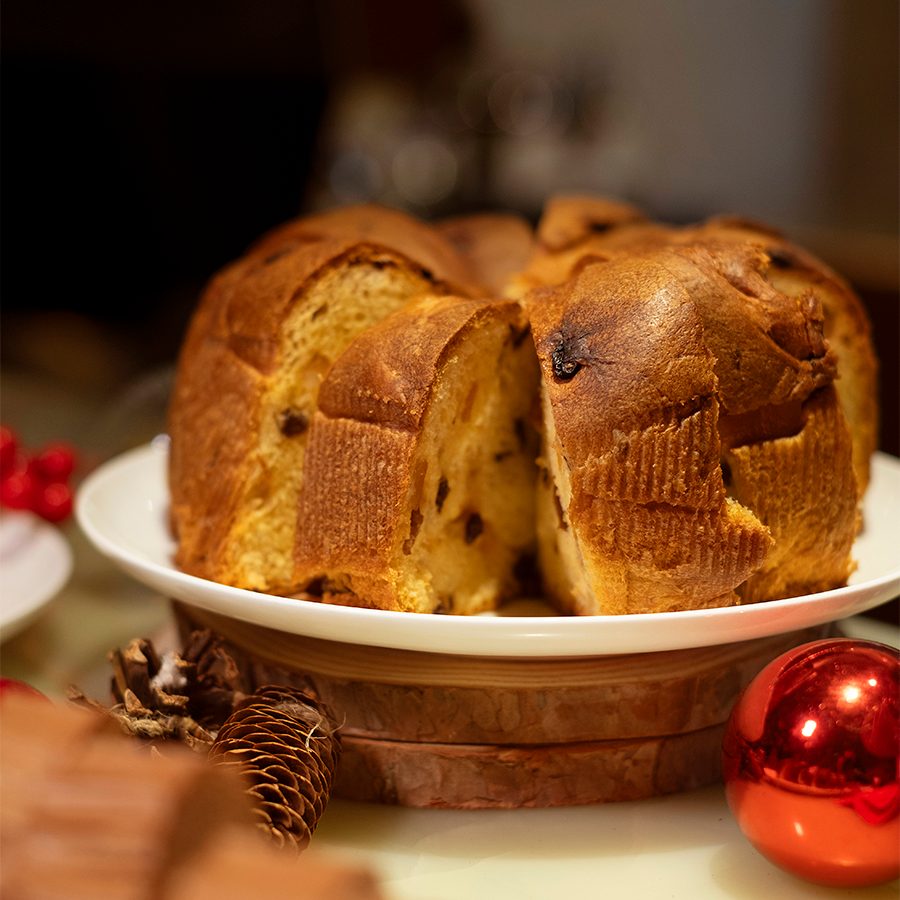 Slices of limoncello panettone on a plate with a red bauble beside it. 