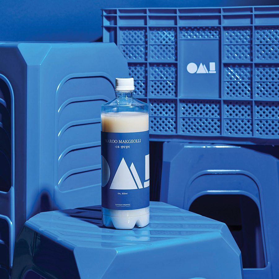 A bottle of Hangang Brewery’s Naroo Draft Makgeolli on a blue chair.