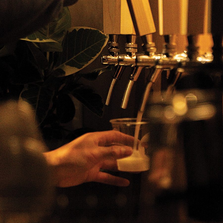 A person filling a cup with sool, an alcoholic beverage in Korea.