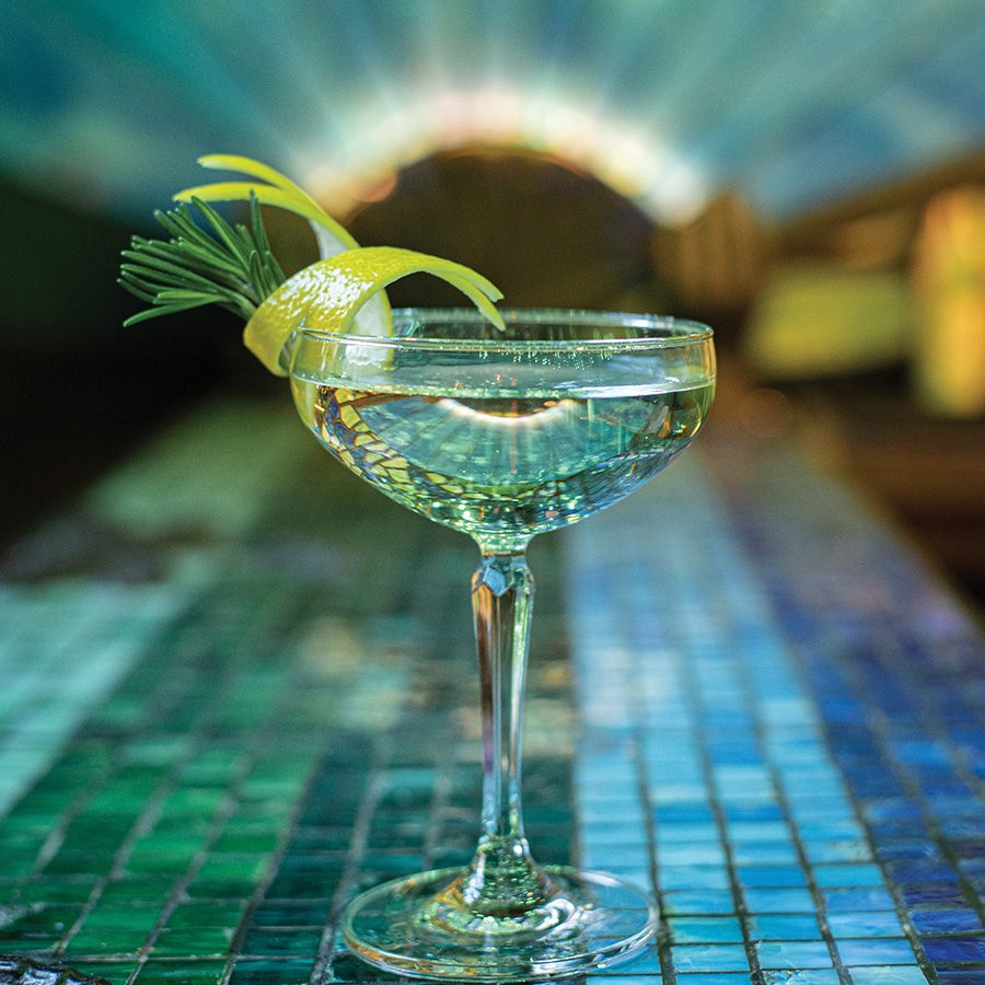 A cocktail with a lemon rind garnish in a coupe glass at Dragonfly, Tai Kwun, Hong Kong.