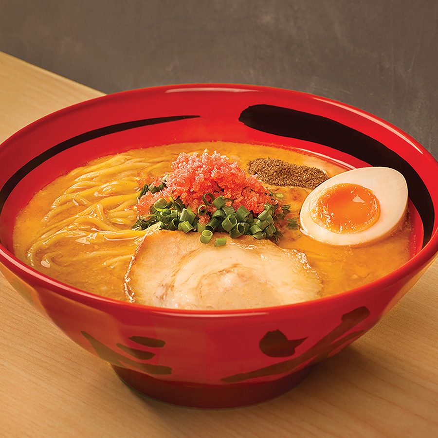 A bowl of ramen with half an egg and slices of pork at Ebisoba Ichigen.