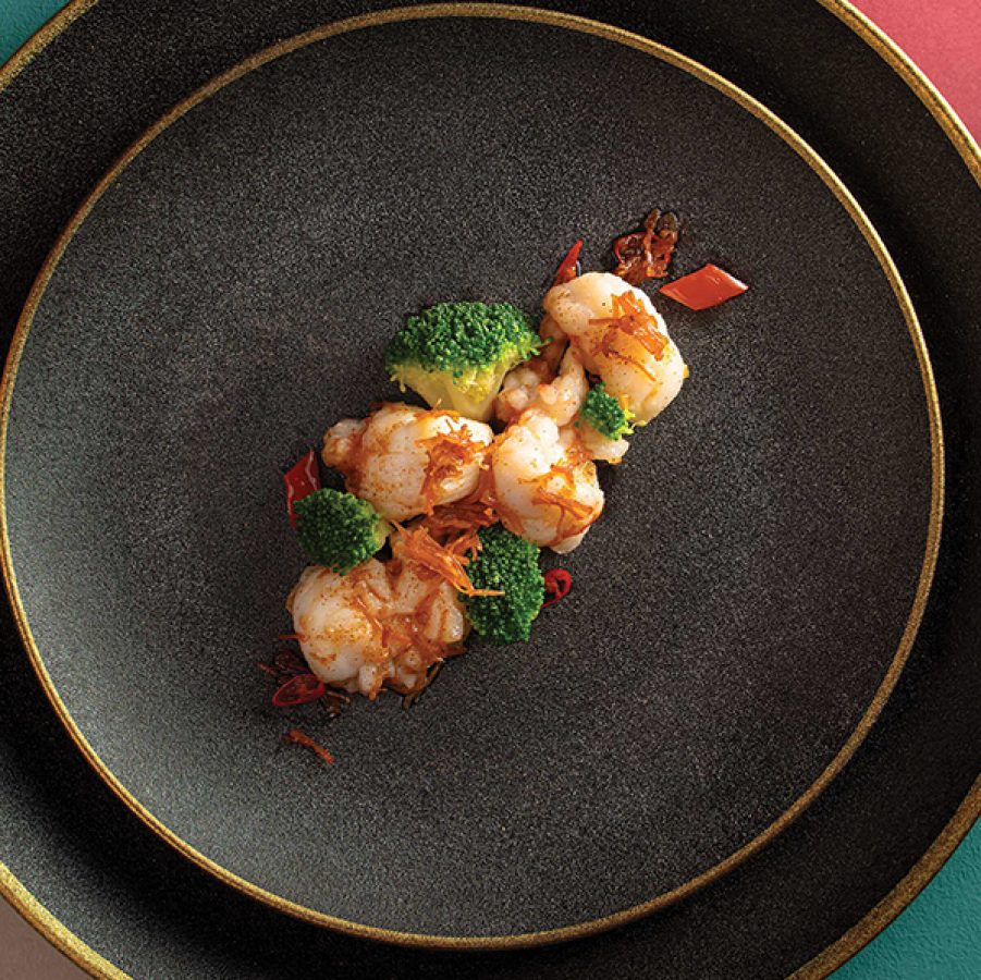A black plate with wok-fried broccoli and lobster at The Jade, Regala Skycity Hotel, Hong Kong.