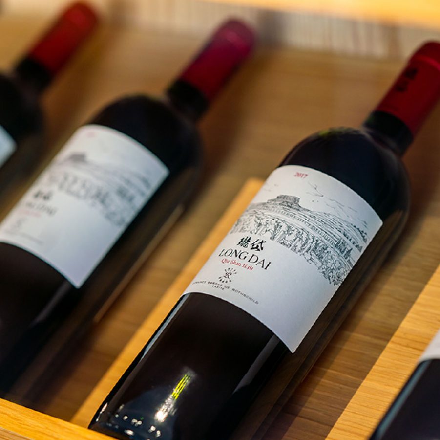 Bottles of red wine on a shelf.