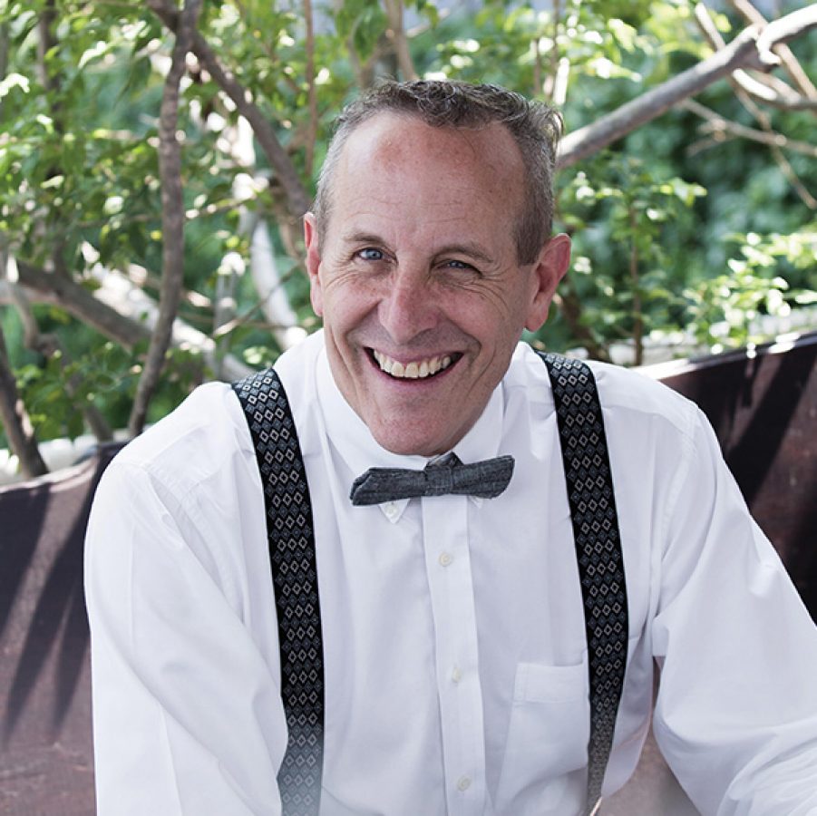 Hotel designer Bill Bensley in a white dress shirt and bowtie, smiling for a picture
