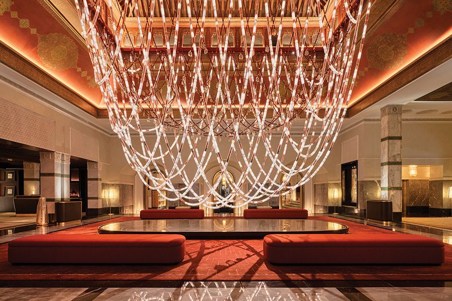 Interior of the lobby at La Mamounia in Marrakech, featuring red couches and a large light installation