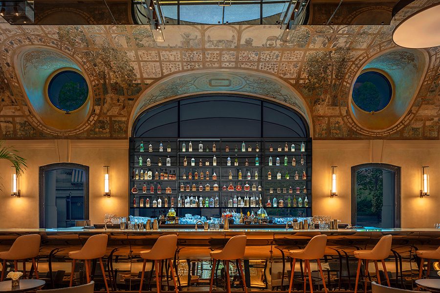 The inside of the library in Hotel Lutetia with bookshelves and a long table with chairs.
