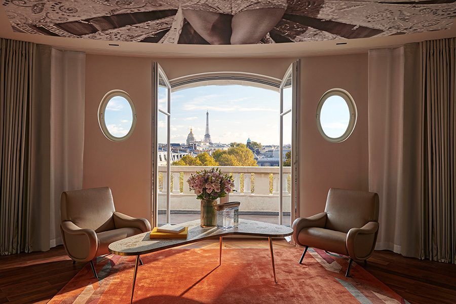 A room in Hotel Lutetia with two chairs and an open terrace facing the Eiffel Tower.