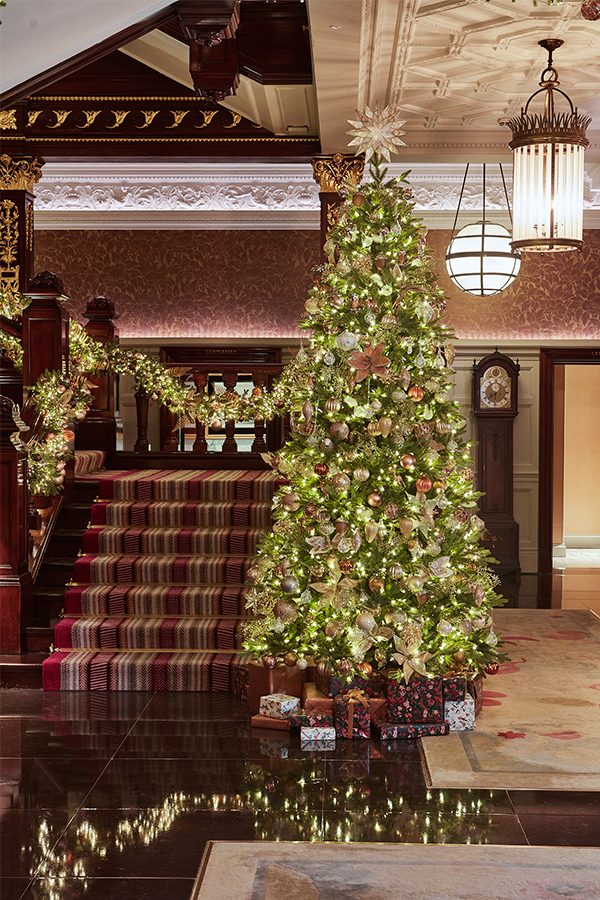 The Connaught lobby with a Christmas tree standing next to a staircase.