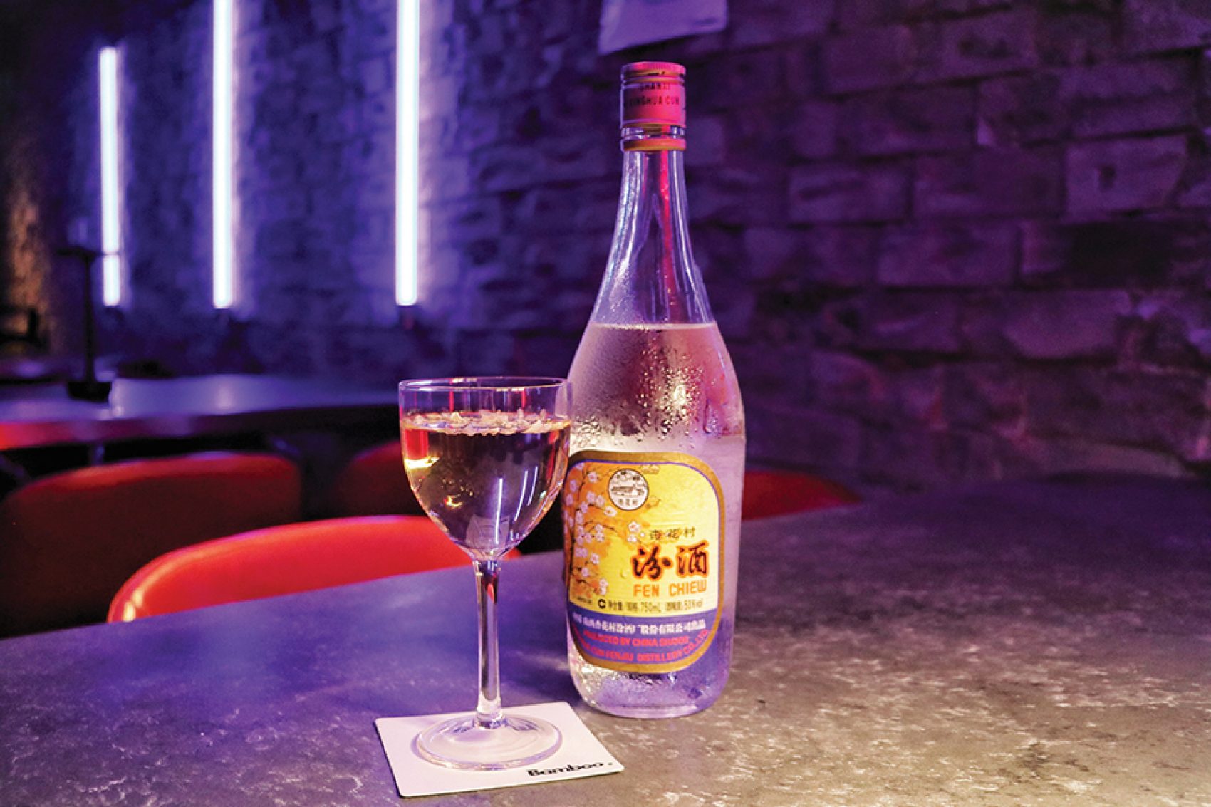 A bottle of Fen Chiew next to a glass at the neon-lit Bamboo bar.