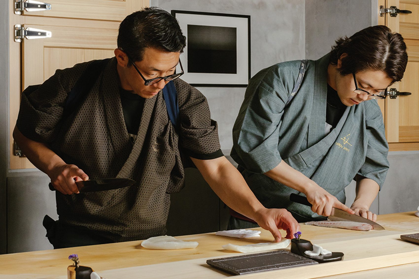 Chefs Hisashi Udatsu and Hiroki Nakamura slicing fish at Udatsu Sushi. 