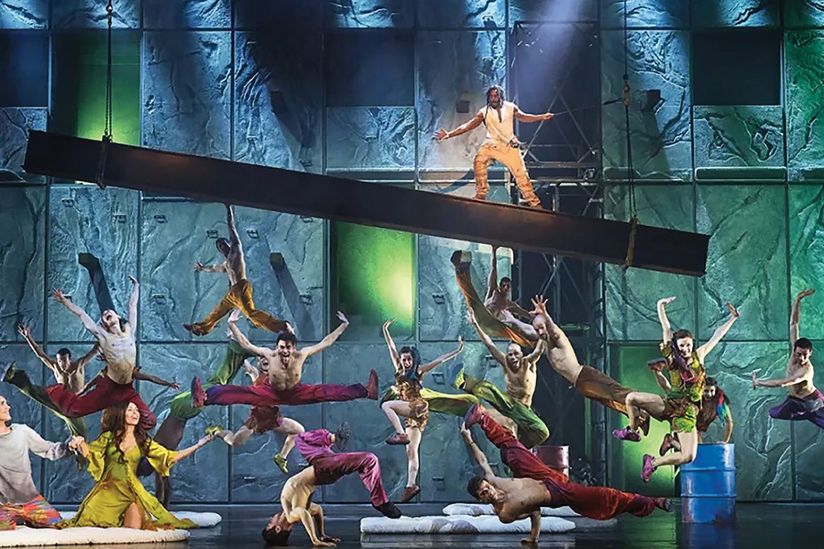 A group of people in colourful clothes dancing on stage for Notre-Dame de Paris.  