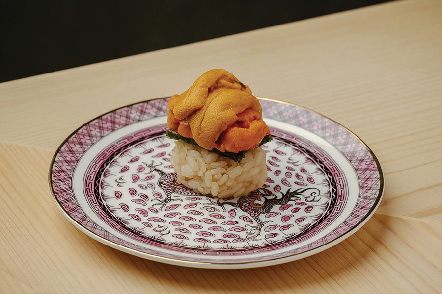 Close-up of sea urchin sushi on a patterned plate.