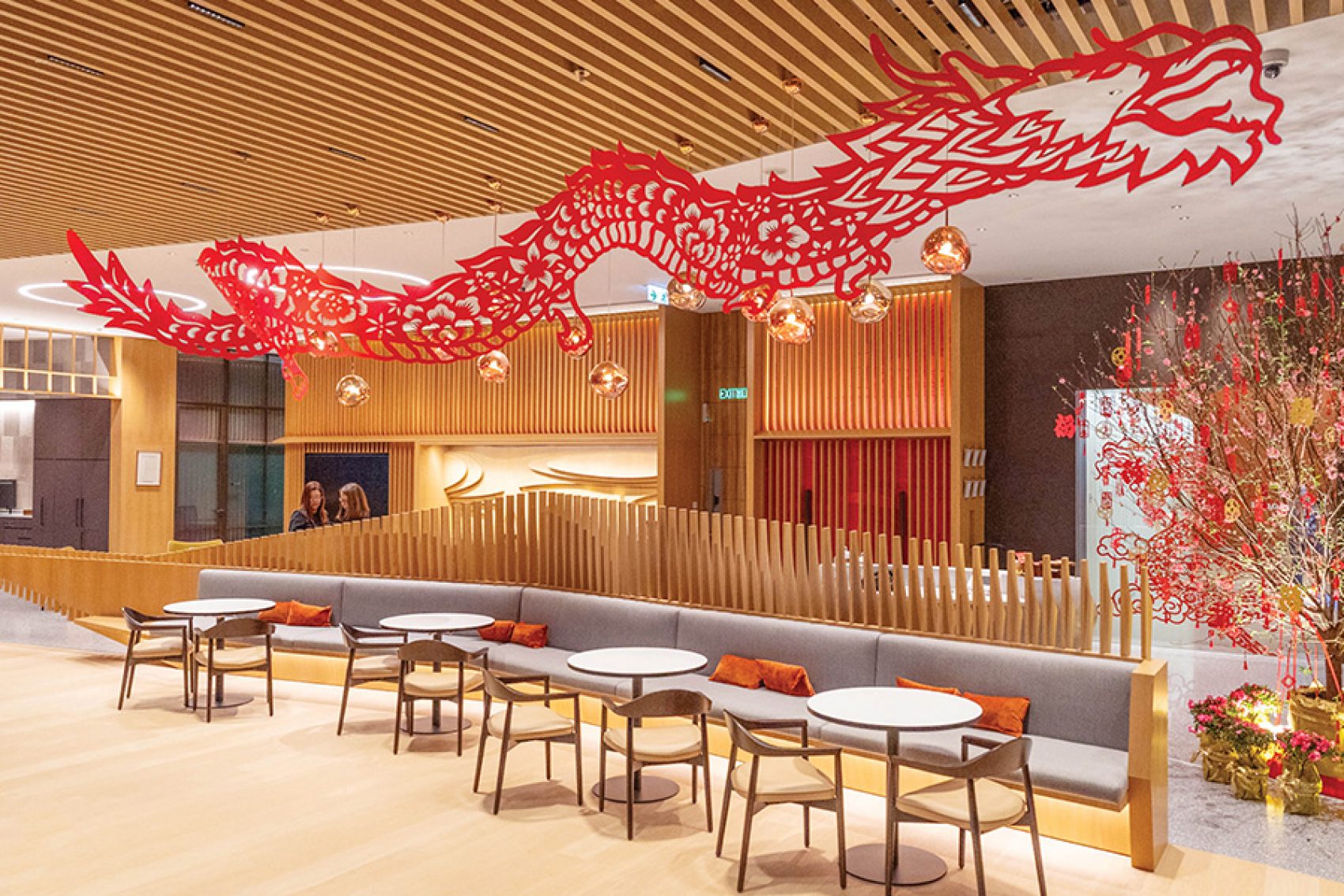A red dragon hanging from the ceiling of an office lobby at One Island East, hand-cut by Nick Tsao.