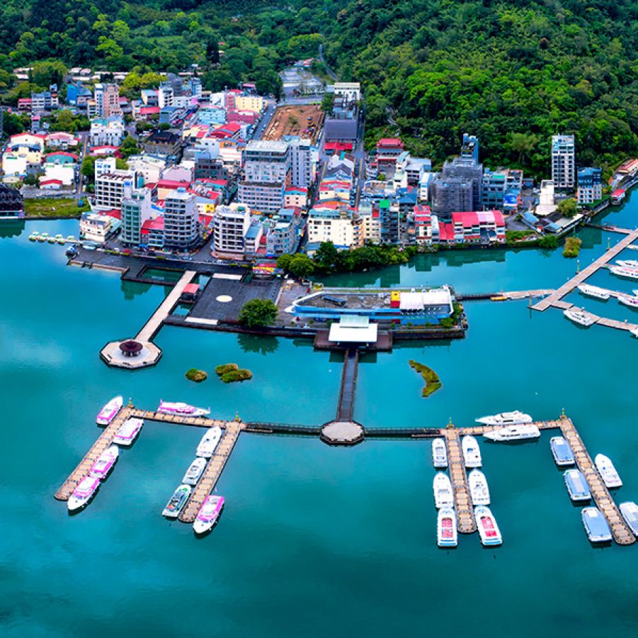 A view from above of vibrant buildings and boats parked neatly in the water at Ita Thao Pier. 