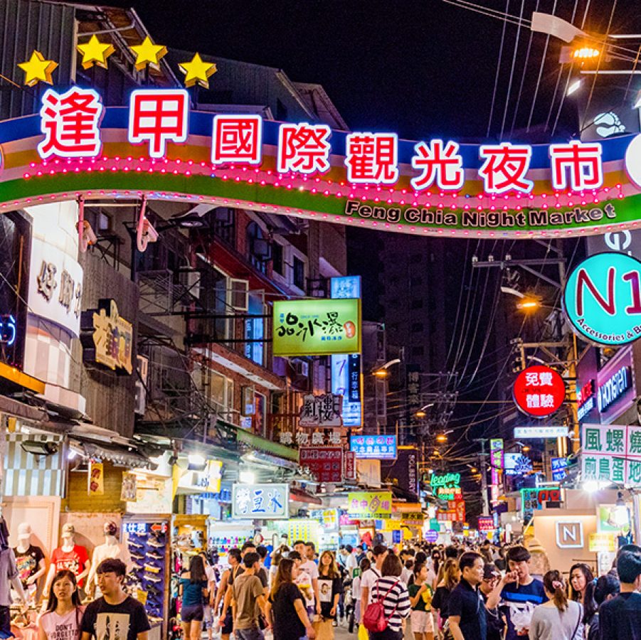 Brightly lit signs and shopfronts at the Fengjia Night Market in Taichung. 