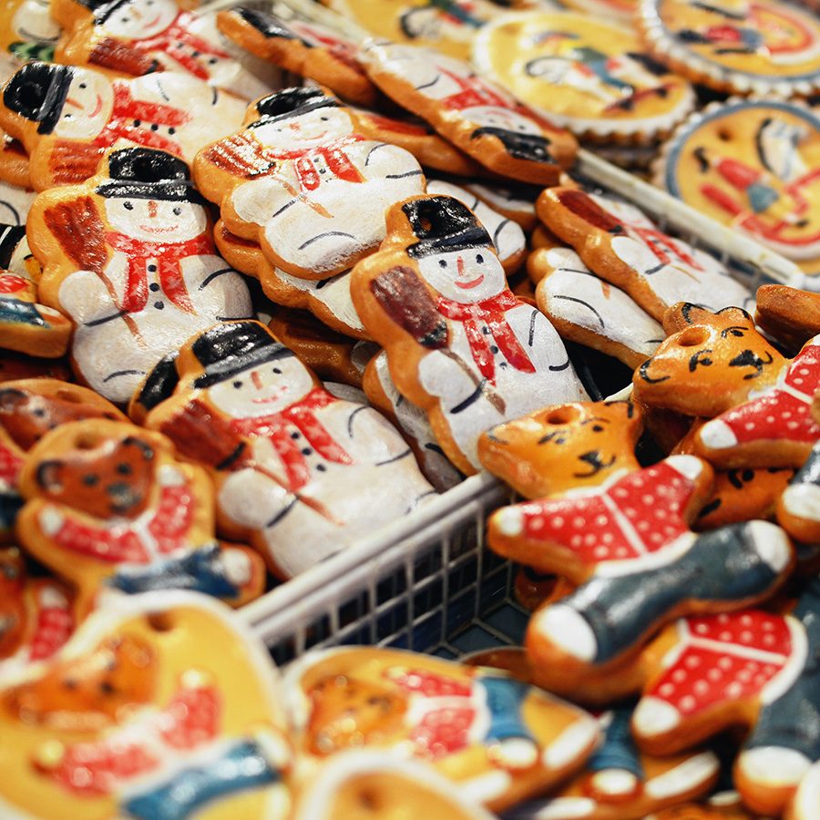 Trays of gingerbread decorations shaped like snowmen and teddy bears at a Christmas market. 