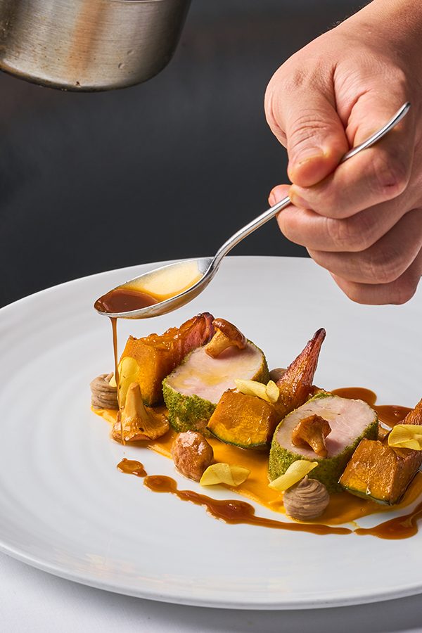 Sauce being dripped onto a dish at Arcane.