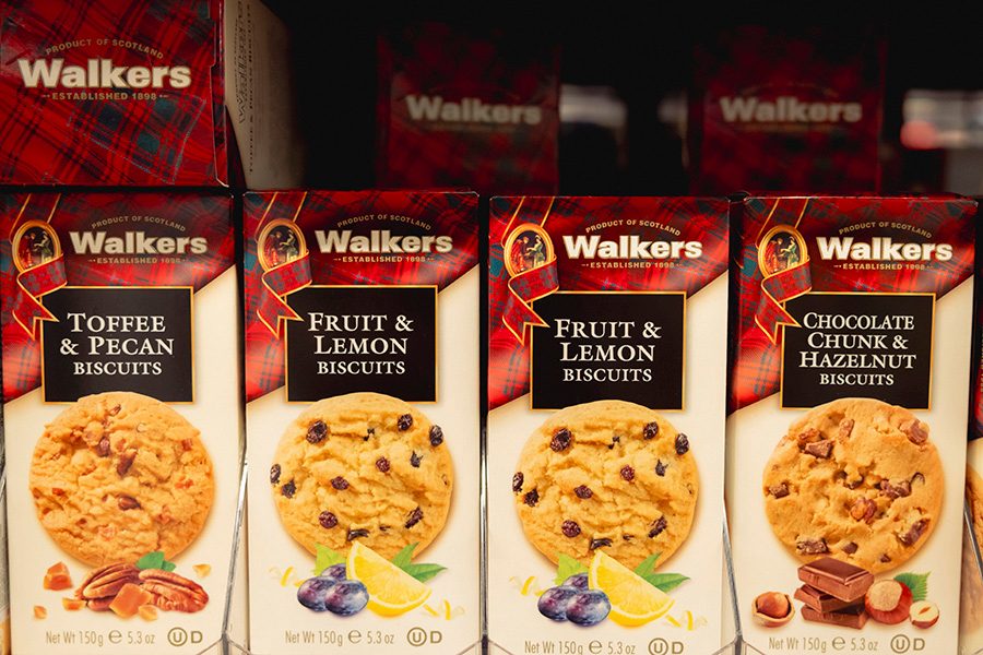 Boxes of Walkers biscuits placed on a shelf at a supermarket in the UK. 
