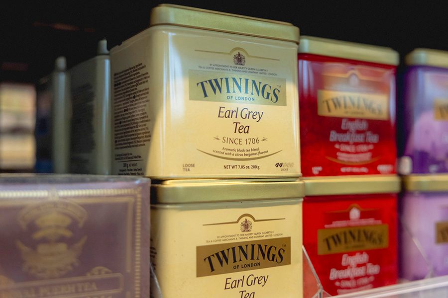 Tin boxes of Twinings tea line a supermarket shelf. 