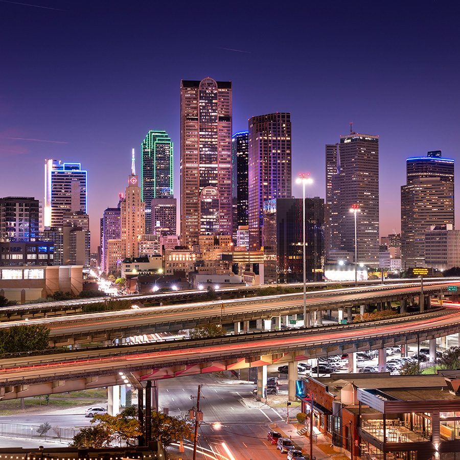 The Deep Ellum entertainment district at night, with the Dallas skyline in the background. 