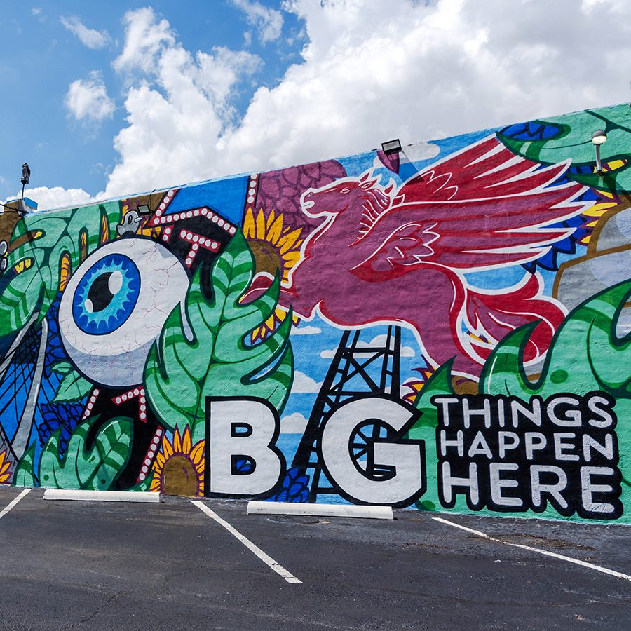 A colourful mural in Deep Ellum with a blue sky behind. 