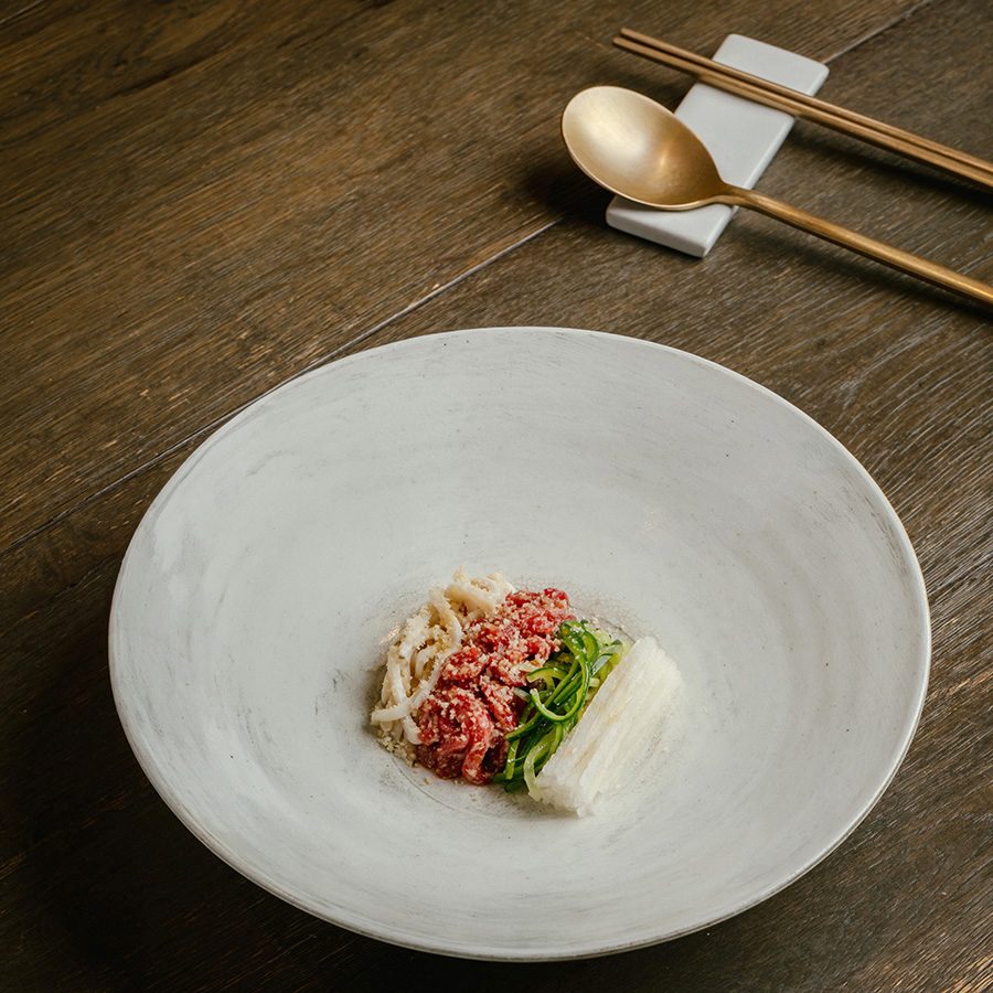 A view of Hanwoo Jeonbok Yukweh on a white plate served at Michelin star restaurant Hansik Goo in Hong Kong. 
