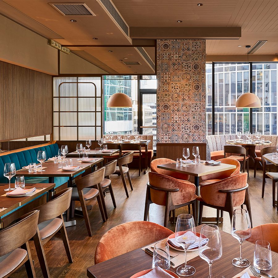An interior view of Quiero Más dining room with large windows, natural sunlight and modern decor.