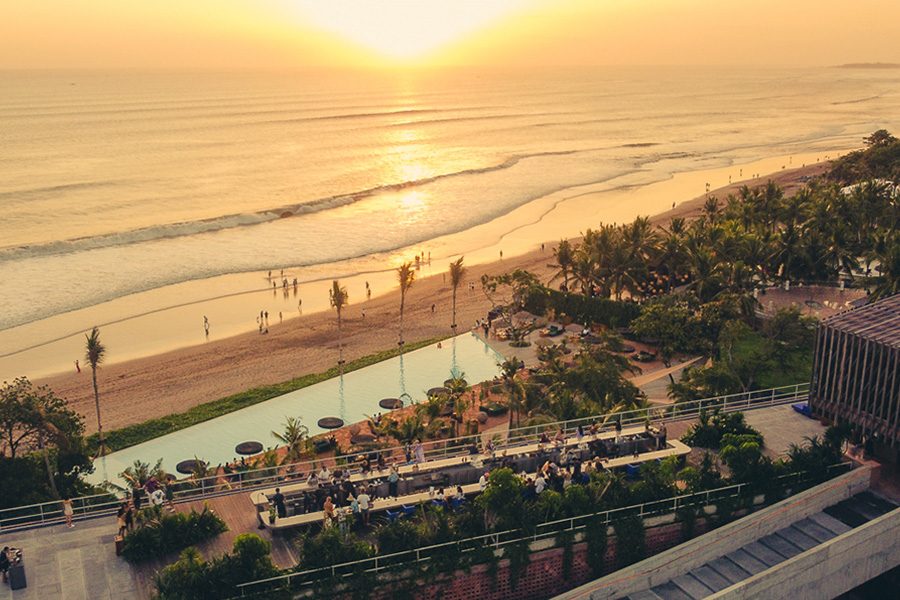 Aerial view of Desa Potato Head, Bali, and the beach at sunset. 