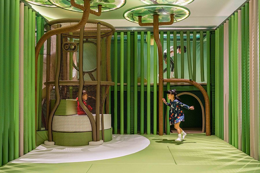 Two children playing inside a green nature-themed area at Fullerton Ocean Park Hotel in Hong Kong