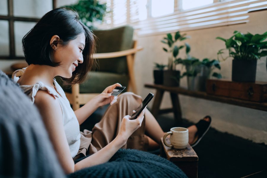 Woman looking at her phone as she has a coffee