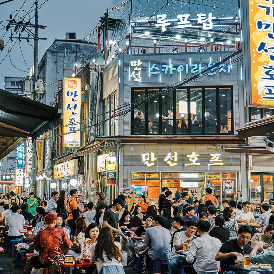 Night time scene in Seoul with dining tables out on the street 