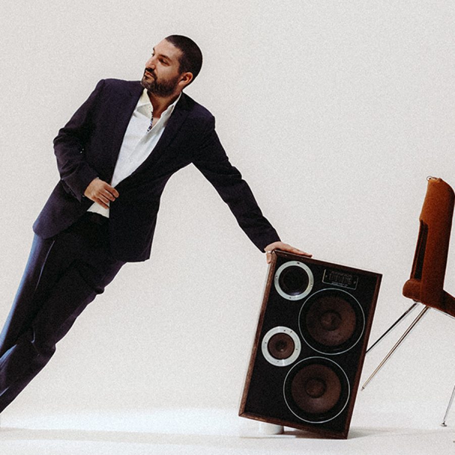 Ibrahim Maalouf is leaning on a hi-fi speaker next to a toppling chair.