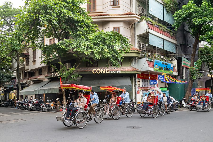 Rickshaws pass by Cong Caphe in Hanoi’s Old Quarter in the daytime.
