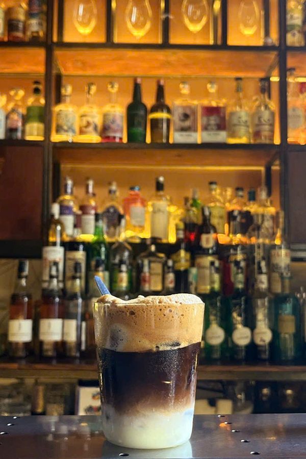 A cup of coffee with ice and condensed milk on the bar at Hanoi House.
