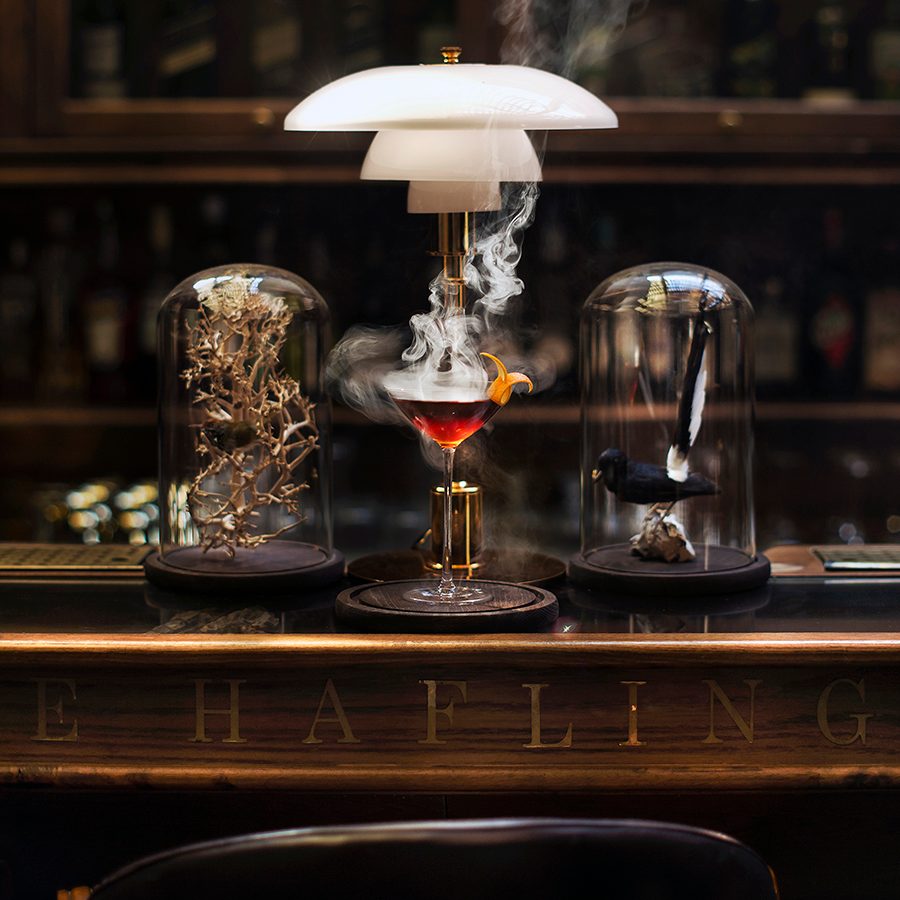 A wisp of smoke trails from a dark orange cocktail served at The Haflington in Hanoi.