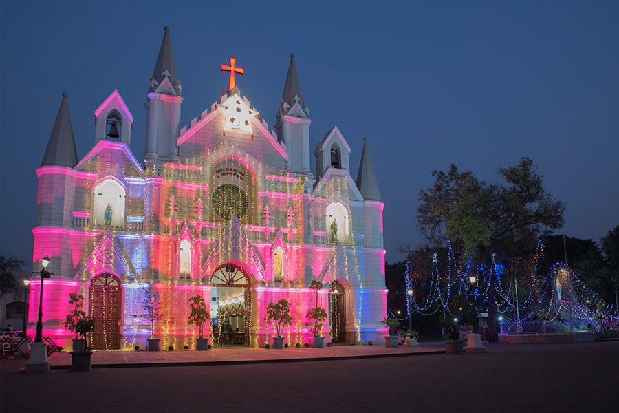 St. Patrick’s Cathedral in India at night, lit up in different colours during Christmastime.