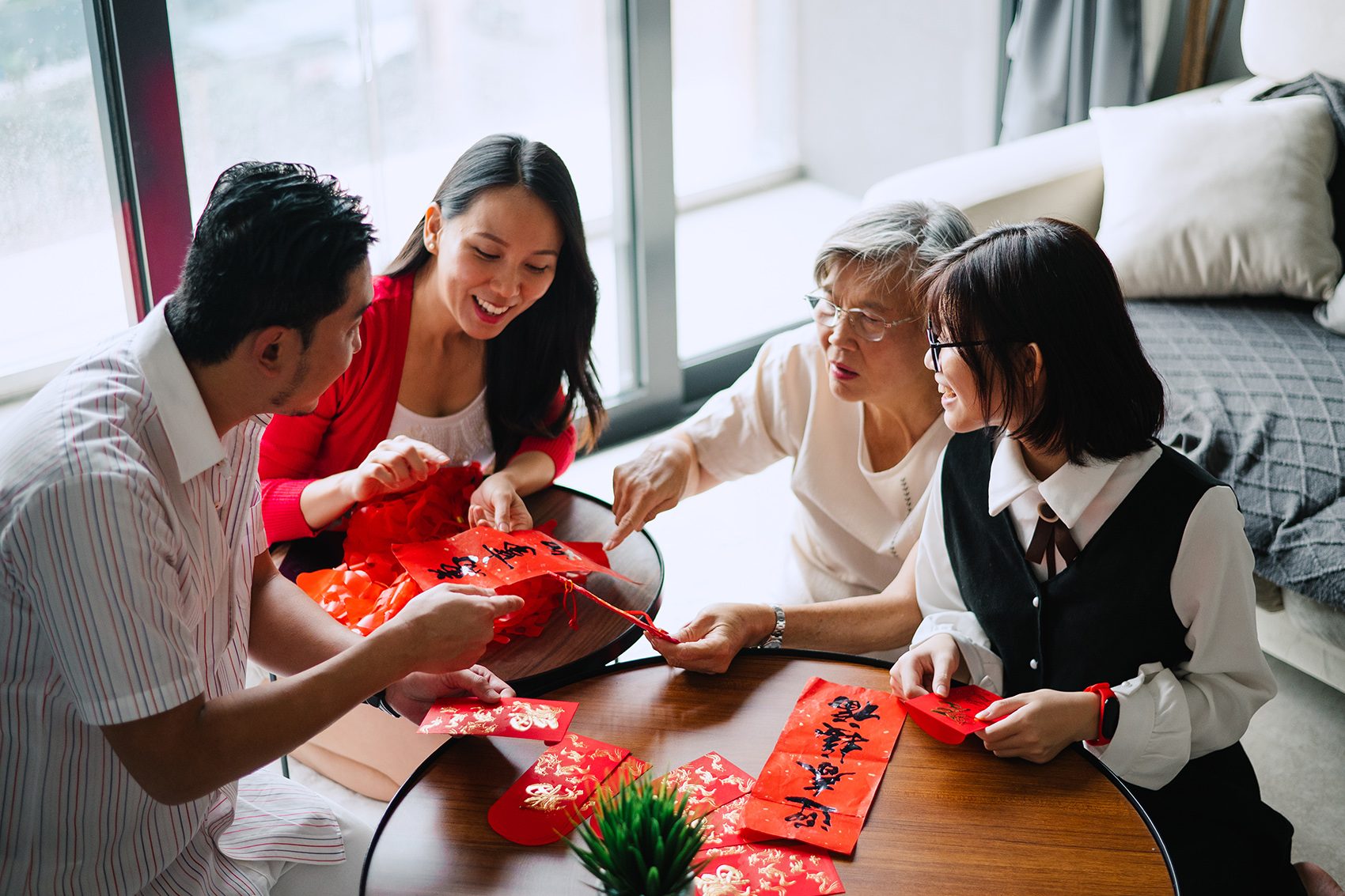 A family sitting around a table with fai chun and lai see.