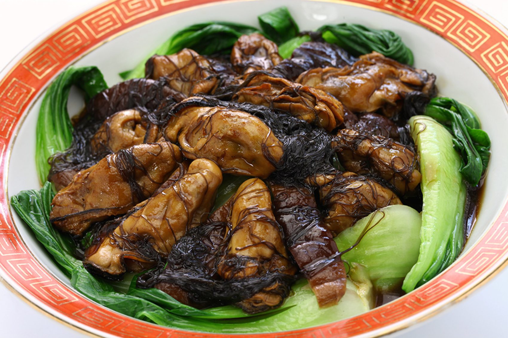 Close-up of braised dry oysters with sea moss and bok choy. 