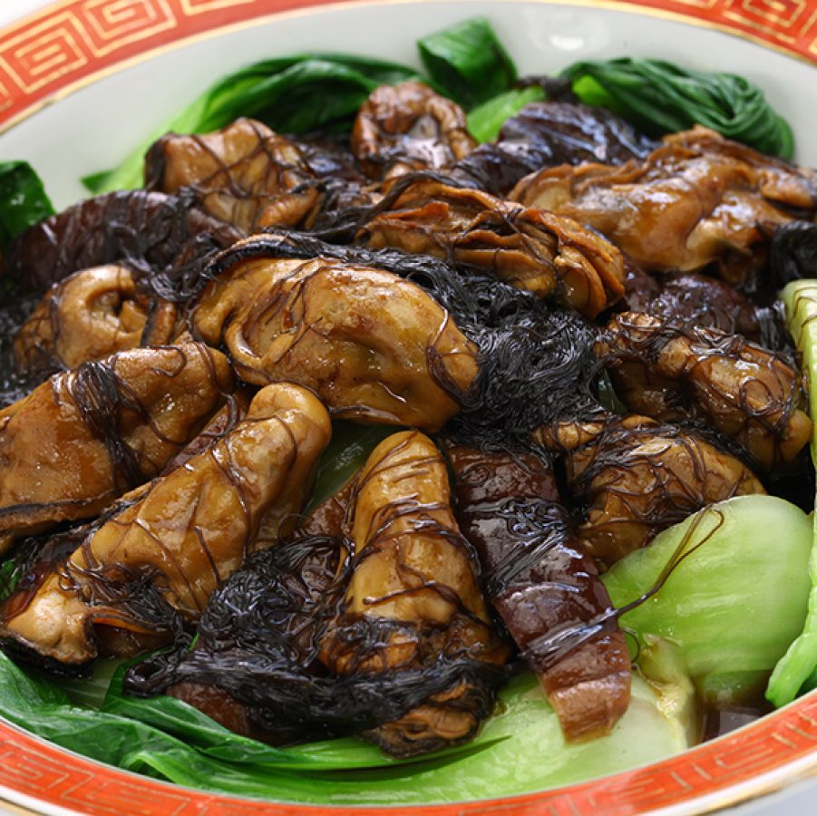 Close-up of braised dry oysters with sea moss and bok choy. 