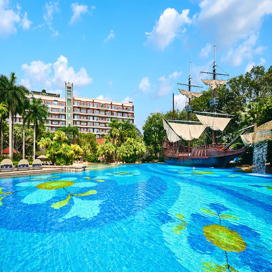 A view of the soft sand beach and outdoor swimming pool with a pirate ship at InterContinental Shenzhen on a sunny day. 