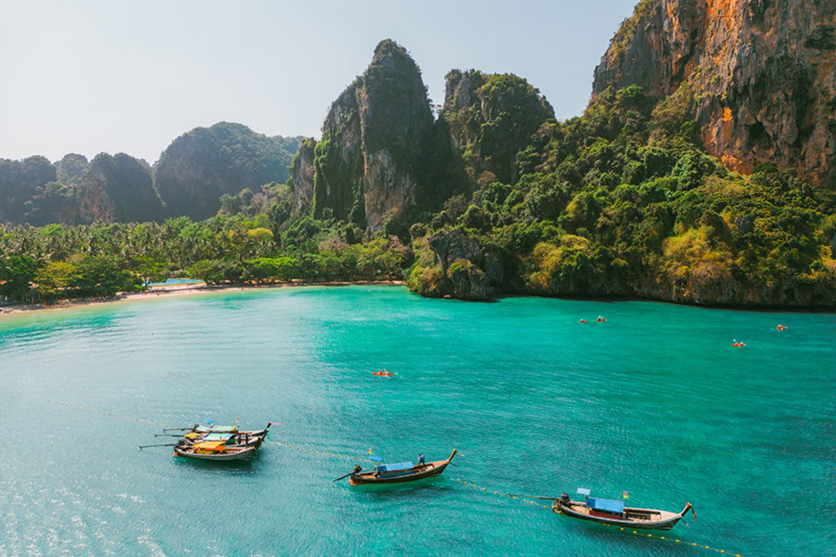 Limestone cliffs behind boats in the water at Krabi. 