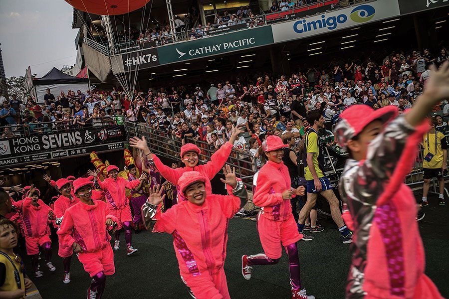 Spectators dressed in pink, running with hands in the air at the Cathay Pacific/HSBC Hong Kong Sevens. 