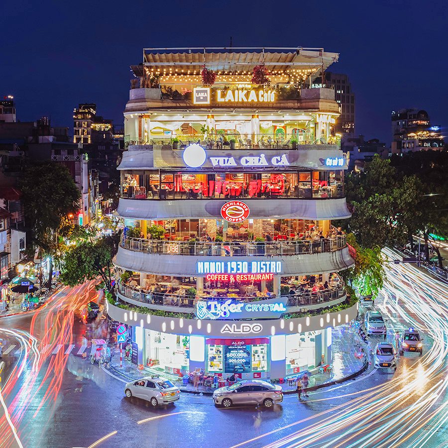 Dong Kinh Nghia Thuc Square in Hanoi’s Old Quarter, lit up with colourful lights at night. 