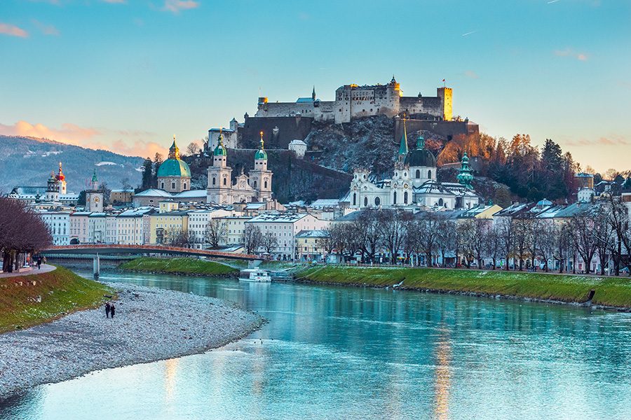 Salzburg’s skyline with Fortress Hohensalzburg on top of Festungsberg Mountain and Salzach River in front. 