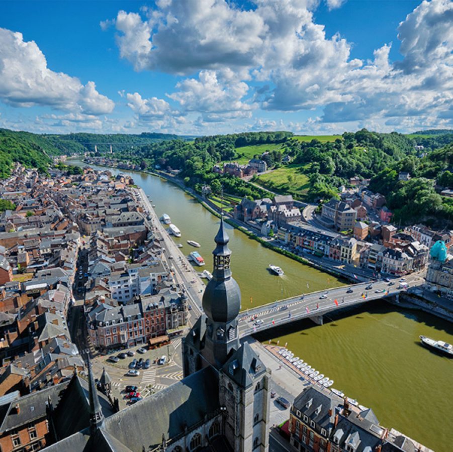 Aerial view of Dinant from the Meuse River and buildings on the riverside to the town’s gothic church and the surrounding greenery.