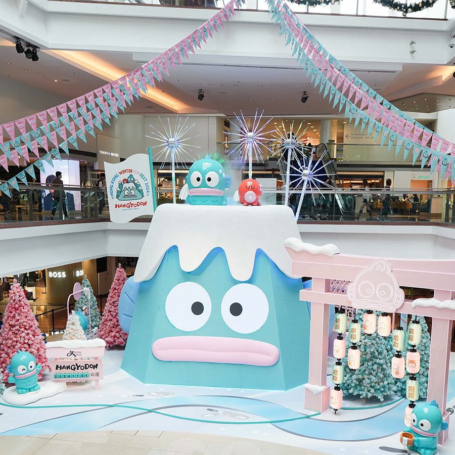 A wide shot of the Hangyodon Winter Fun Fest display at Festival Walk, featuring a turquoise mountain with a Hangyodon face on it and a pink Japanese torii gate.