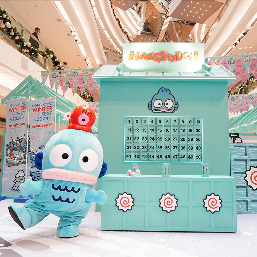  A figure dressed in a Hangyodon costume stands next to an interactive game at the Hangyodon Winter Fun Fest display at Festival Walk.